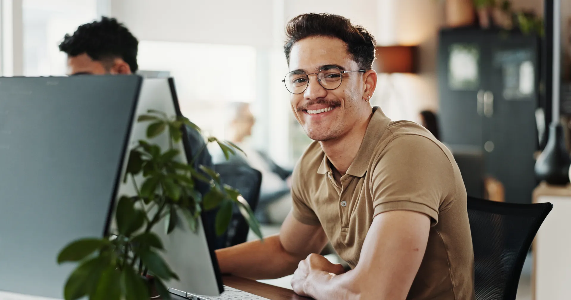 Een glimlachende man werkt op een computer