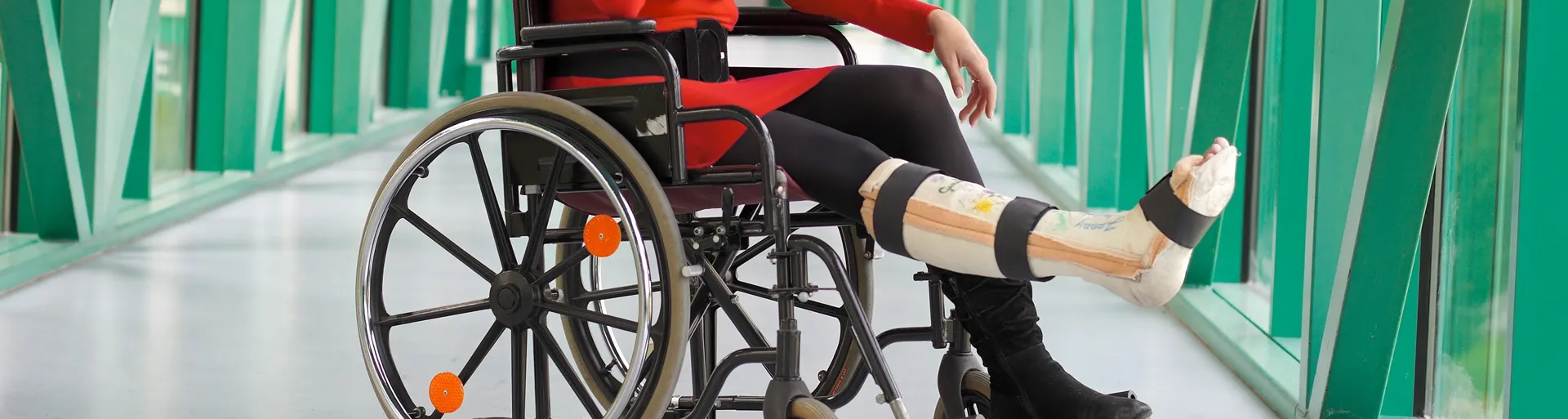 Vrouw zit in rolstoel met gebroken been
